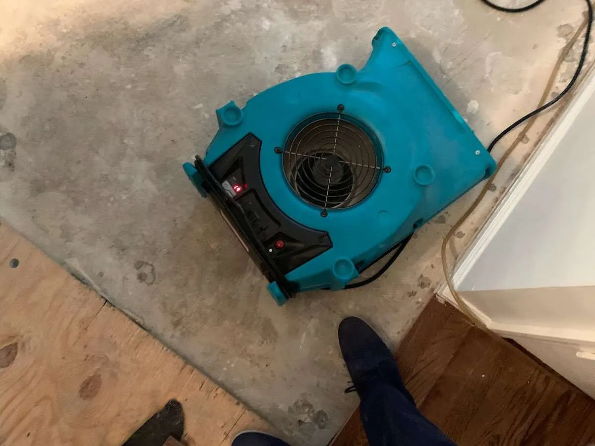 Air mover drying subfloor during Commercial Water Damage Restoration in Delhi